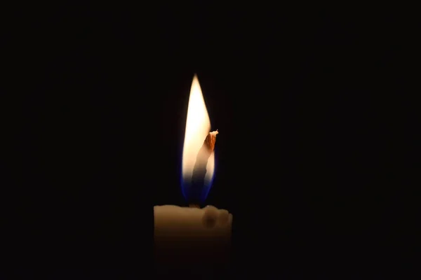 Single Candle with flame in the dark place, isolated black background
