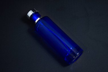 Şeffaf Koyu Mavi Şişe Parfümü tasarım için izole edilmiş siyah arkaplan