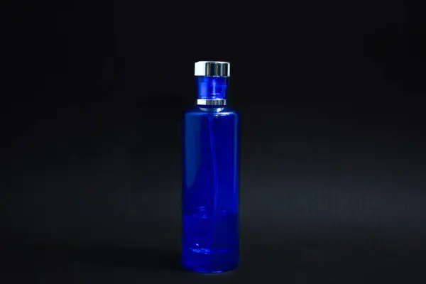 Şeffaf Koyu Mavi Şişe Parfümü tasarım için izole edilmiş siyah arkaplan