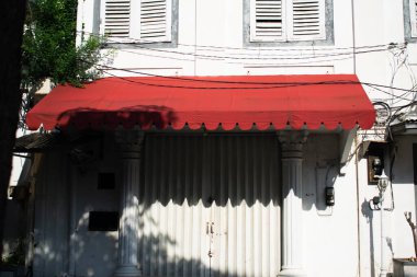 Beyaz eski vintage binanın üzerindeki kırmızı gölgelik mağaza önü