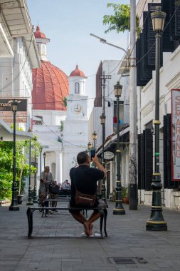 Semarang, Endonezya - 26 Nisan 2024. Kota Lama 'da sokak lambası ve büyük kırmızı kubbeli bir kilise ön planda.