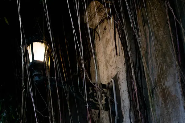 Ürkütücü karanlık bir gecede eski duvarda asılı klasik bir sokak feneri. Kopya alanı olan siyah sokak lambası