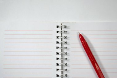 Beyaz arkaplanda izole edilmiş defteri ve kırmızı kalemi aç