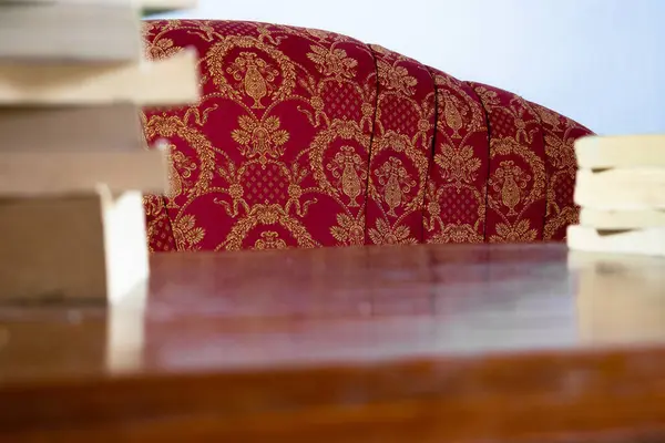 Masada arka plan kitabı ve oturma odasında beyaz duvarı olan kırmızı kanepe.