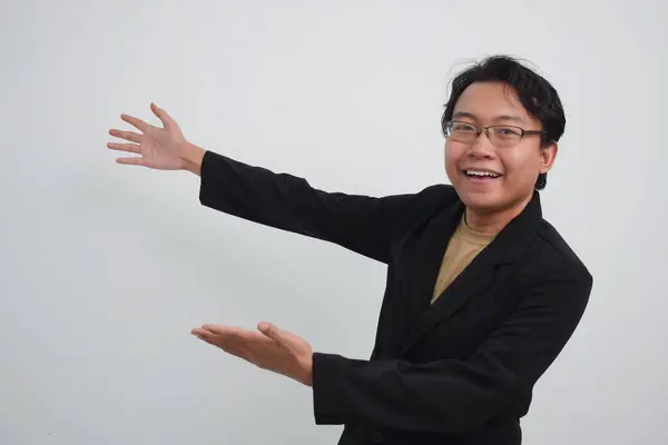 Asyalı İşadamı, arkasında iki eliyle, izole edilmiş beyaz grupla ürününü gösteriyor.