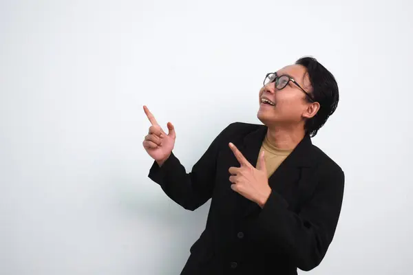 Takım elbiseli ve günlük gömlekli neşeli Asyalı işadamı ürününü gösteriyor ya da izole beyaz arka planda işaret ediyor.