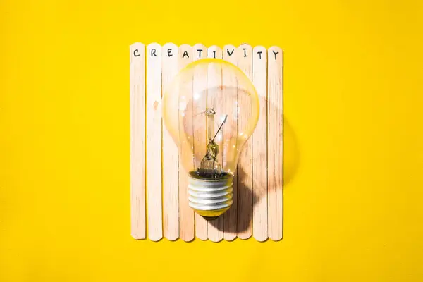 İçinde yaratıcılık ve ampul olan bir dondurma çubuğu. Motivasyon alıntıları, iyimserlik, olumlu kelimeler. Sırt grubunda izole