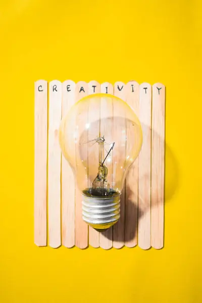 İçinde yaratıcılık ve ampul olan bir dondurma çubuğu. Motivasyon alıntıları, iyimserlik, olumlu kelimeler. Sırt grubunda izole