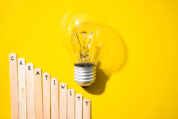 İçinde yaratıcılık ve ampul olan bir dondurma çubuğu. Motivasyon alıntıları, iyimserlik, olumlu kelimeler. Sırt grubunda izole