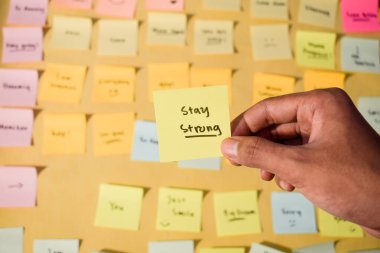 Sözcüklerle el ele tutuşan yapışkan notlar, kişisel gelişim için motive edici kelimeler, ilham verici el yazısı. Yapışkan notlar