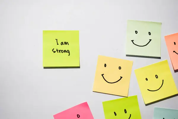 Güçlüyüm ve yapışkan notalarda gülümsüyorum. Kişisel gelişim için motivasyon, ilham verici el yazısı. Sırt grubunda izole