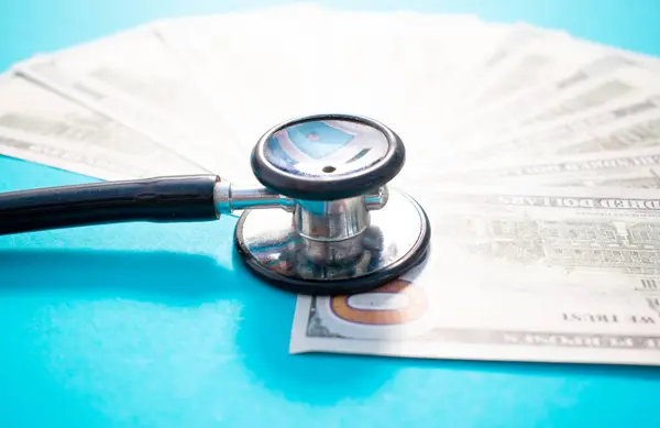 Stetoskop, Amerikan doları banknotu ve basılı istatistik tablosu. Mali, hesap, istatistik ve mali sağlık kavramı