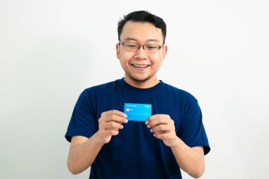 Mutlu Asyalı adamın kredi kartı var. Bankacılık, finansal tecrit, mavi konsept