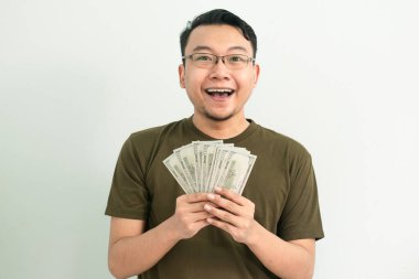 Mutlu Asyalı adam Money 'i tutuyor. Bankacılık, finansal izole, yeşil renk konsepti