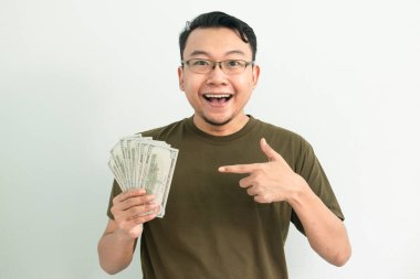 Para gösteren mutlu Asyalı adam. Bankacılık, finans ve teknoloji izole edilmiş, yeşil renk kavramı