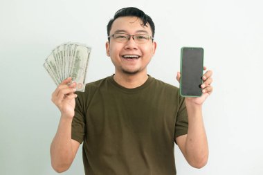 Mutlu Asyalı adam Money 'i tutuyor ve ekranı gösteriyor. Bankacılık, finans ve teknoloji izole edilmiş, yeşil renk kavramı