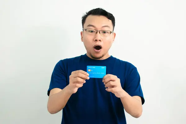Asyalı adamın kredi kartını göstermesine şaşırdım. Bankacılık, finansal izole, mavi renk konsepti