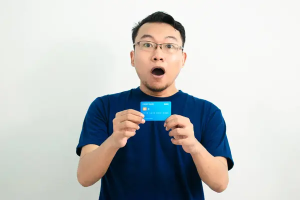 Asyalı adamın kredi kartını göstermesine şaşırdım. Bankacılık, finansal izole, mavi renk konsepti