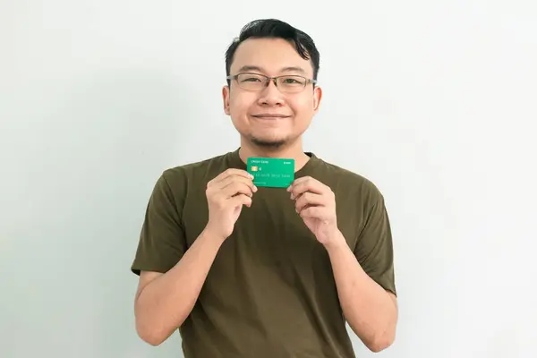 Mutlu Asyalı adamın kredi kartı var. Bankacılık, finansal izole, yeşil renk konsepti