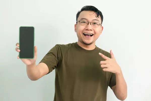 Telefonu gösteren mutlu Asyalı adam. portre izole edilmiş, yeşil renk konsepti