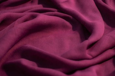 Yumuşak mor kumaş dalgalı sarmal buruşuk arkaplan dokusu ve ortasında kopya alanı.