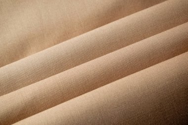 Çok katlanmış açık kahverengi kumaş arkaplan dokusu.