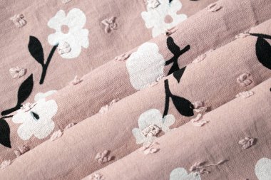 Katlanmış pembe kumaş arkaplan dokusunda çiçek deseni.