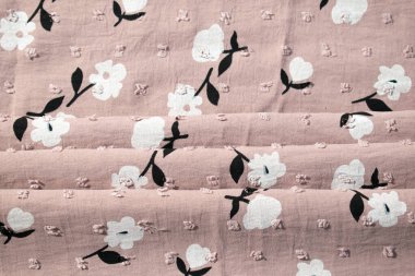 Katlanmış pembe kumaş arkaplan dokusunda çiçek deseni.