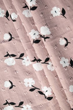 Katlanmış pembe kumaş arkaplan dokusunda çiçek deseni.