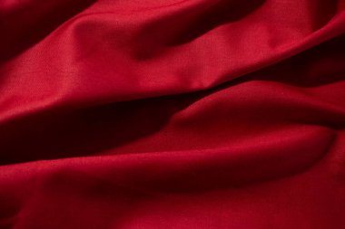 Buruşuk dalgalı kırmızı ipeksi kumaş arkaplan dokusunu kapat. sinsi ve ışıltılı.