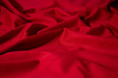 Buruşuk dalgalı kırmızı ipeksi kumaş arkaplan dokusu. sinsi ve ışıltılı.