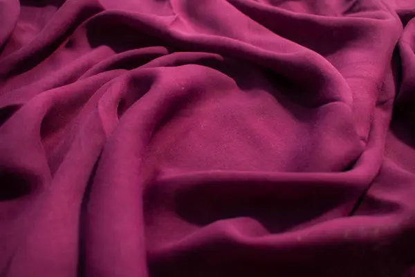 Yumuşak mor kumaş dalgalı sarmal buruşuk arkaplan dokusu ve ortasında kopya alanı.
