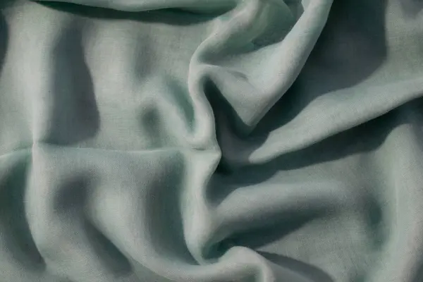 Çıplak yeşil kumaş dalgalı buruşuk arkaplan dokusu kopya alanı ile.