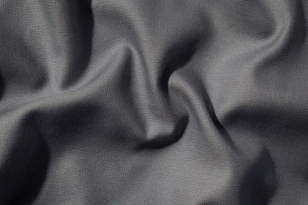 Buruşuk dalgalı koyu gri ipeksi kumaş arkaplan dokusu. sinsi ve ışıltılı.