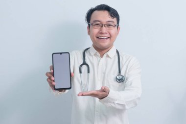 Neşeli Asyalı erkek doktor, erkek hemşire sunan ve gösteren telefon izole beyaz arka plan.