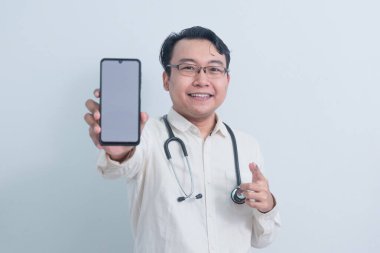 Mutlu Asyalı erkek doktor, erkek hemşire telefonu gösterip izole beyaz arka plan gösteriyor..