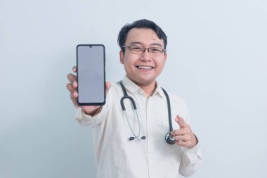 Mutlu Asyalı erkek doktor, erkek hemşire telefonu gösterip izole beyaz arka plan gösteriyor..