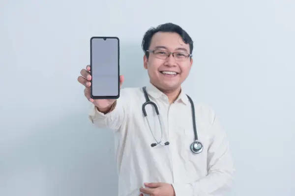 Mutlu Asyalı erkek doktor, erkek hemşire telefonu gösterip izole beyaz arka plan gösteriyor..