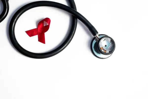Kırmızı kurdele ve steteskop, HIV farkındalığı konsepti, dünya AIDS günü, dünya kanseri günü izole edilmiş beyaz arka plan.