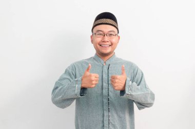 Asyalı Müslüman adam Ramazan Bayramı 'nda el işareti yapıyor ve Kurban Bayramı' nda izole edilmiş beyaz arka planı kutluyor. İslami kutlama kavramı.