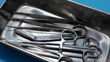 El doktoru, metal tepsiden cerrahi makas ya da forseps alır. Cerrahi alet tıbbi ve sağlık hizmetleri