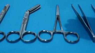 El doktoru mavi arka planda cerrahi aletler kullansın. Cerrahi alet tıbbi ve sağlık hizmetleri