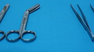 El doktoru mavi arka planda cerrahi aletler kullansın. Cerrahi alet tıbbi ve sağlık hizmetleri