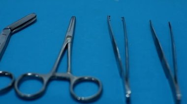Mavi arkaplanı olan bir sıra cerrahi alet.