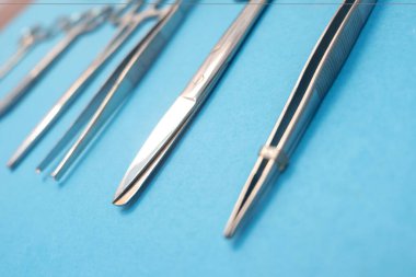 Mavi arka planda cerrahi alet seti. Makas ve forseps de dahil. Tıbbi malzemeler...