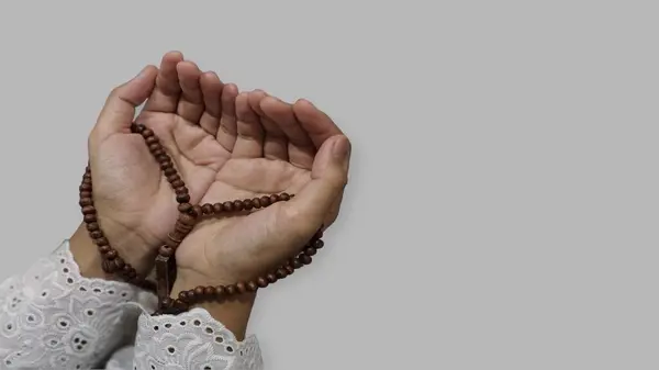 Müslümanların dua eden elleri Ramazan 'da tespih tutar, izole edilmiş gri arkaplan