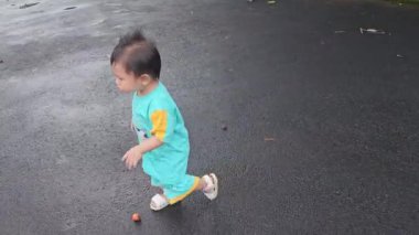 Bebek ayakkabıyla sokakta koşuyor. Parkın bulutlu havasında asfaltta, açlık mevsiminde koşan çocuk ayaklarının yakın çekimi. Mutlu aile çocuk konsepti. Bebek koşuyor ve rüyalarda oynuyor.
