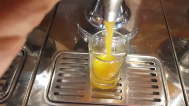 Taze portakal suyu bardağa dökülür. Gri arka planı olan taze portakal meyveleri. Sağlıklı vejetaryen içeceği. Vitaminler içer..