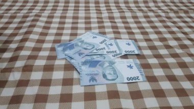 Endonezya para birimi notları atan eller Masa 'nın arka planına düşen 2.000 ve 10000.