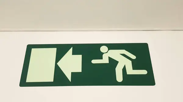 Green emergency exit sign showing the way to escape. Fire exit in the building. emergency sign consept